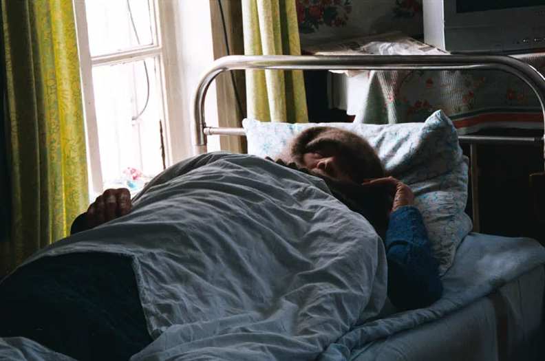 Перед смертью много спят. Больной в кровати. Больная старушка на кровати. Старушка лежит на кровати. Больная женщина в кровати.